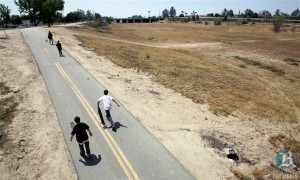 Skateboarders scoot along the Kern River parkway next to the dry Kern River.  Photo by Casey Christie